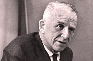 A black and white portrait of a man in a suit looking off-camera.