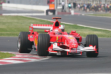 Une voiture de Formule 1 rouge en mouvement sur un circuit.