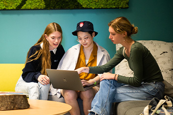 people sitting on couches looking at a laptop