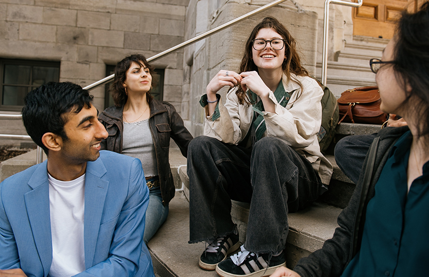 Personnes assises sur des marches devant un immeuble