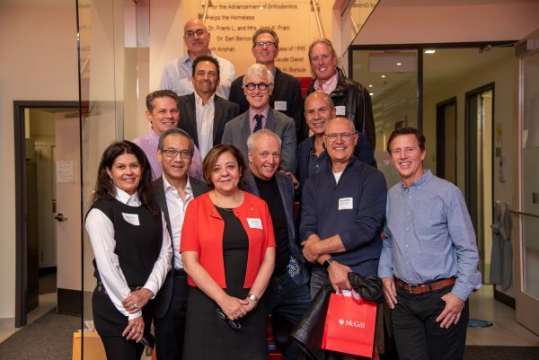 Dean Emami stands with a happy group of Dental Medicine Alumni